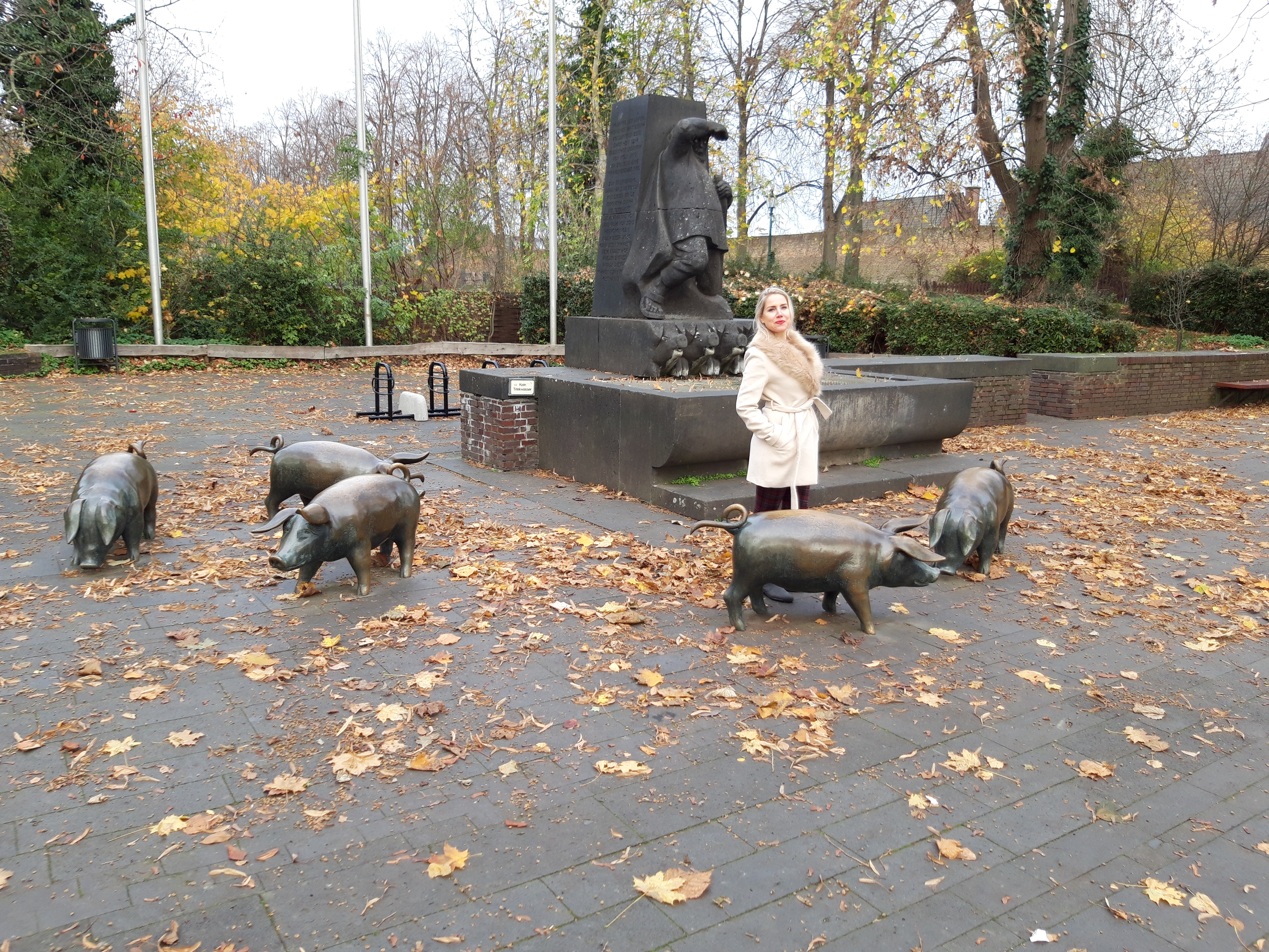 Eunice among bronze pig statues in a park